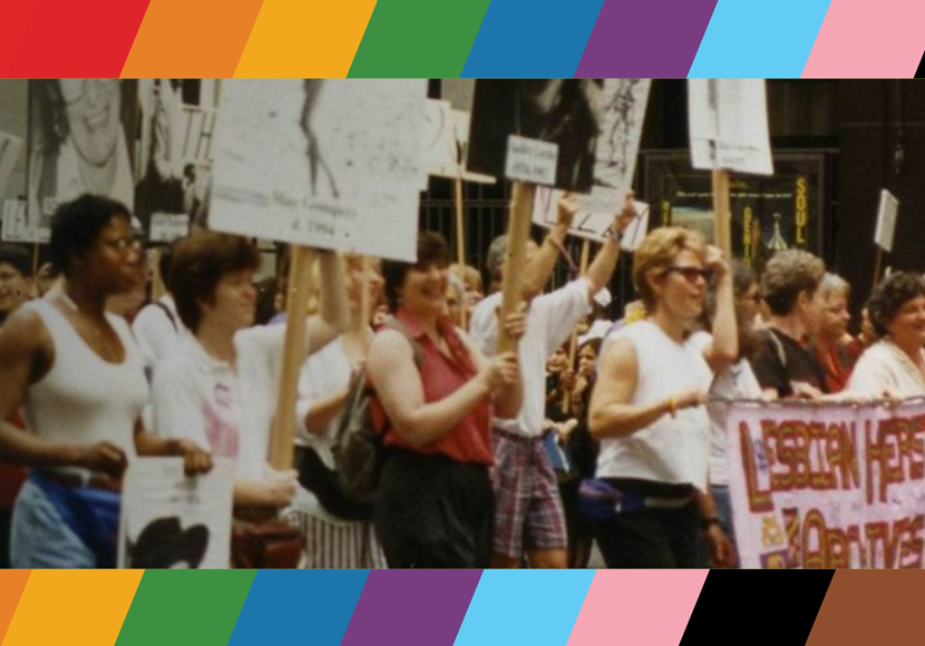 A crowd of people, many holding signs.